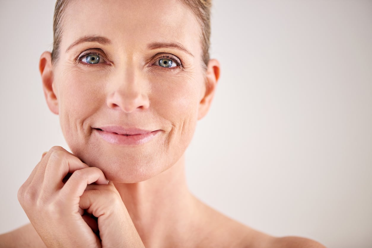 A smiling mature woman with a youthful glow after PRF treatment.