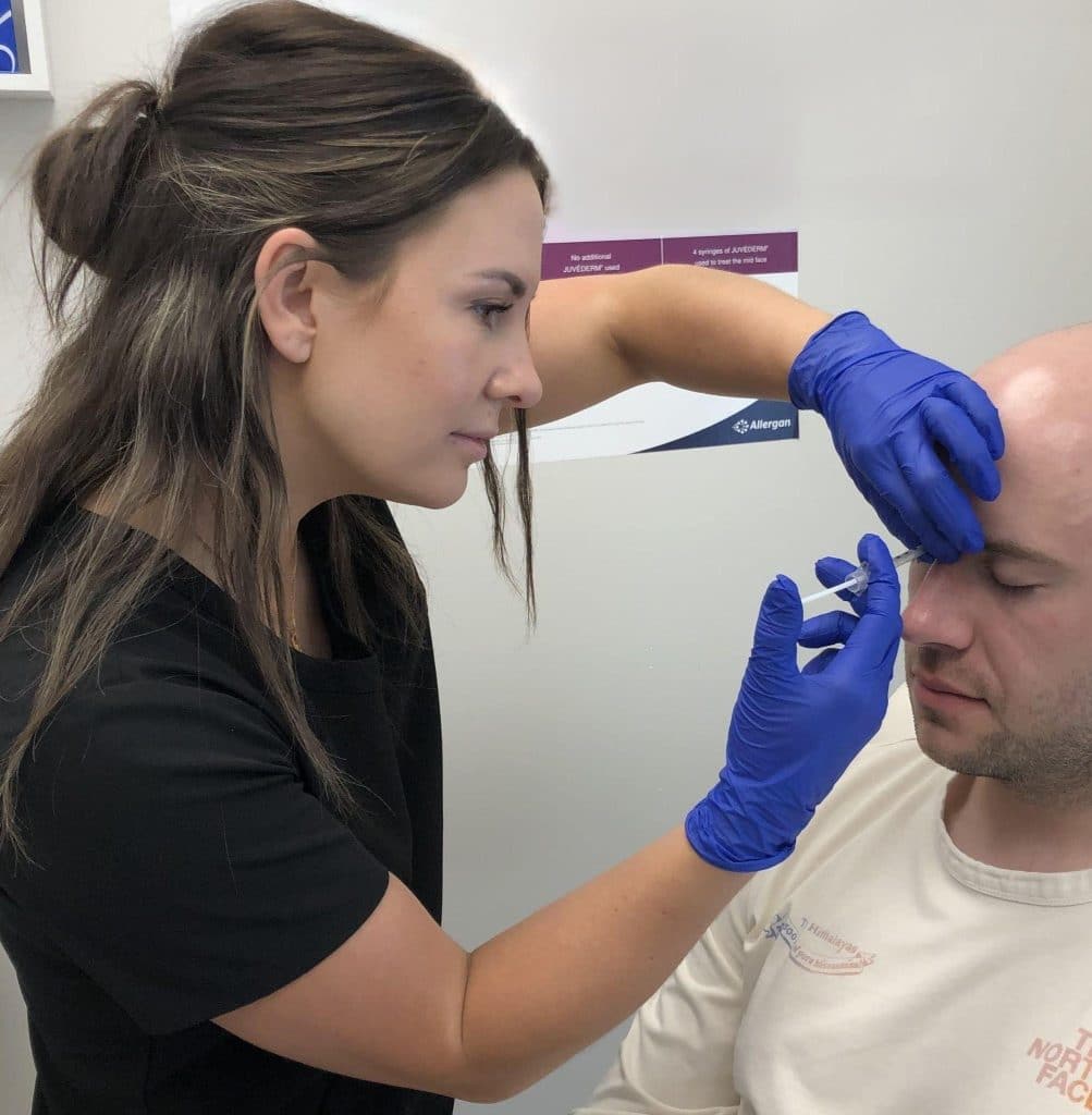 Injector treating glabellar lines between the eyebrows with Botox