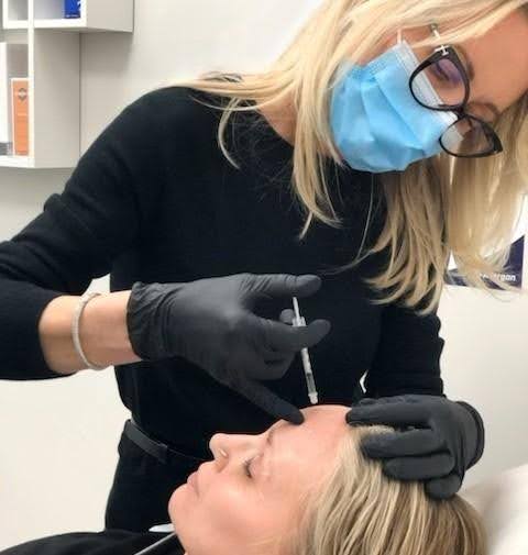 Practitioner administering Botox injections to forehead lines